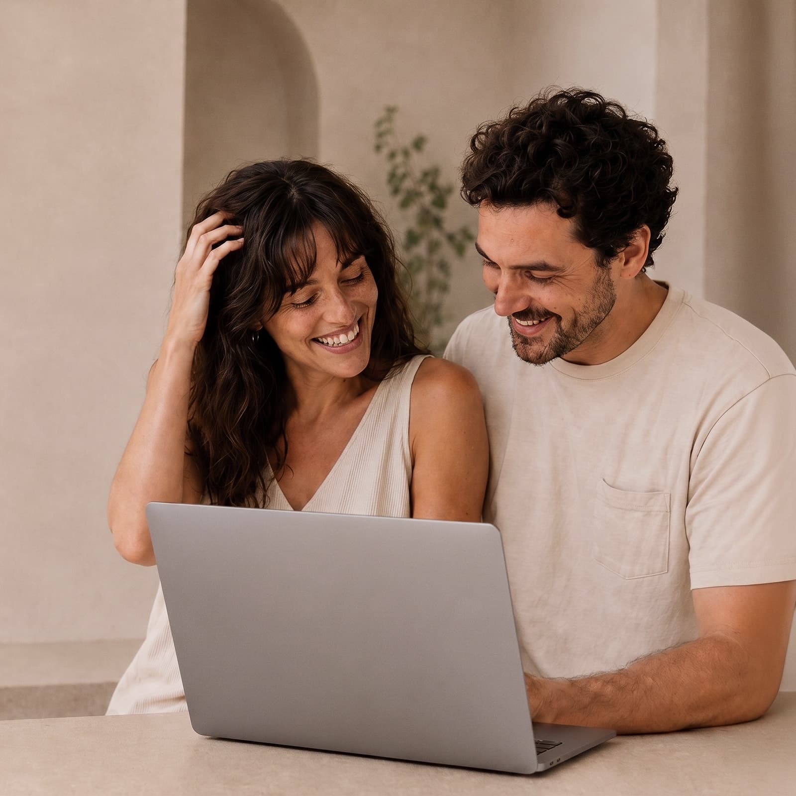 Happy couple smiling together while browsing on a laptop